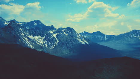 aerial over valley with snow capped mountains in distance