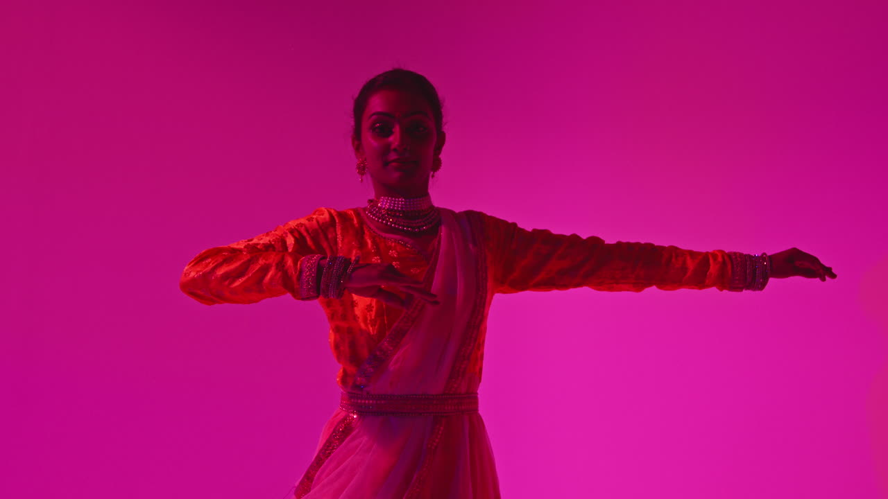 Waist Up Studio Shot Of Female Kathak Dancer Performing Dance Wearing Traditional Indian Dress Against Purple Background 1