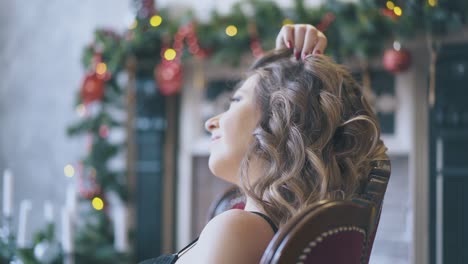 pregnant-woman-sits-in-armchair-at-Christmas-decorations