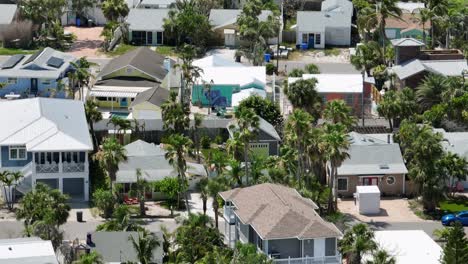 aerial daytime view of cozy coastal neighborhood in treasure island, florida. colorful beach houses, palm trees and a tropical atmosphere under bright sun. aerial wide shot