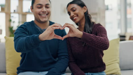 Hands,-heart-and-couple-on-sofa-happy