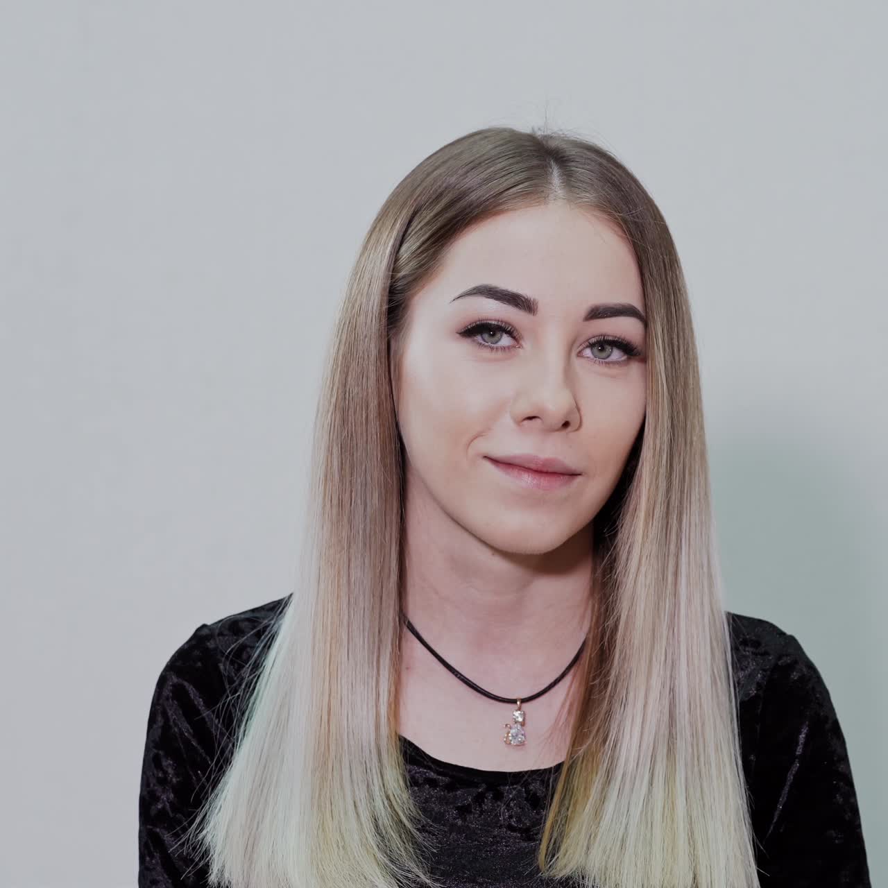 Portrait of a girl with unpainted lips. Natural facial features of a young girl. Beautiful blonde woman in the light studio.