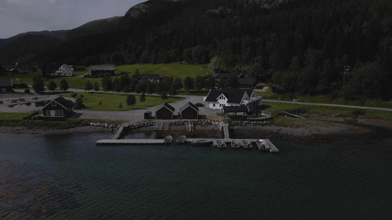 Aerial View Of Norwegian Cabins With Boats Moored On Marina In Nordland, Norway. - pull back, tilt up