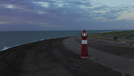 el faro de westkapelle durante una puesta de sol naranja brillante, con mucho viento