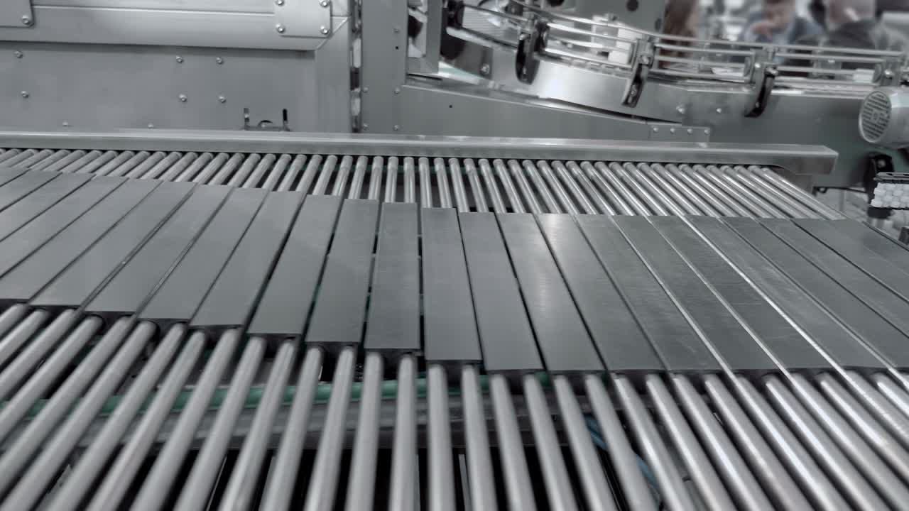 산업 공장 내의 카드보드 상자에 있는 다양한 종류의 상품에 대한 흐름 제어 장치가 있는 컨베이어 벨트.