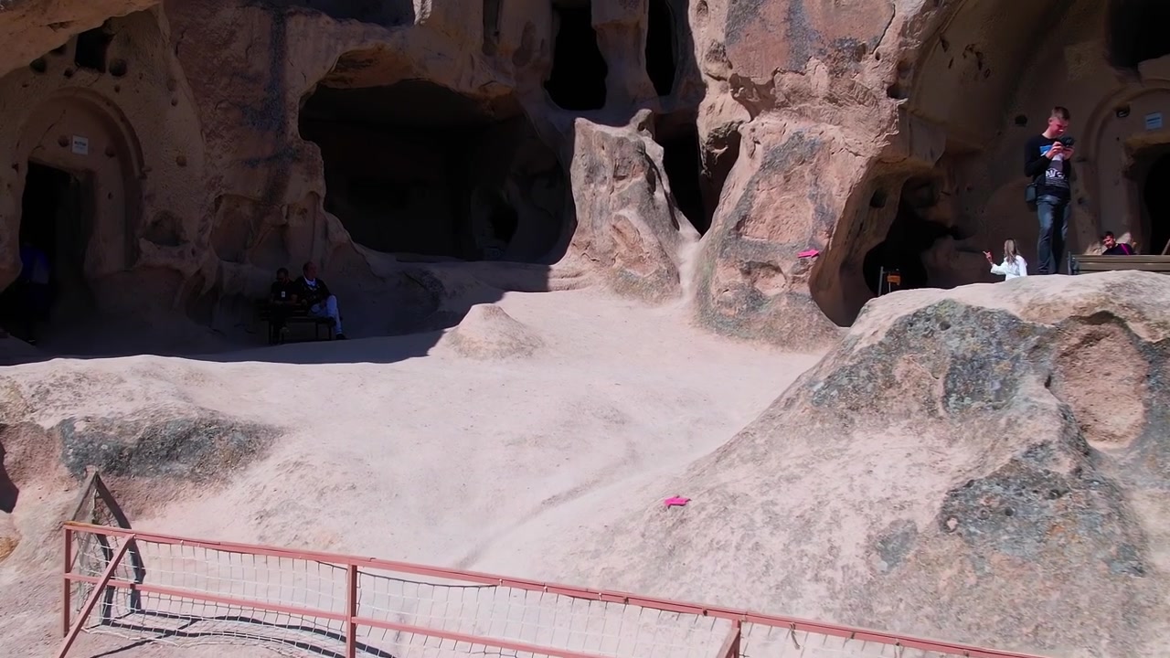 Caves and rock formations in Cappadocia with visitors exploring on foot