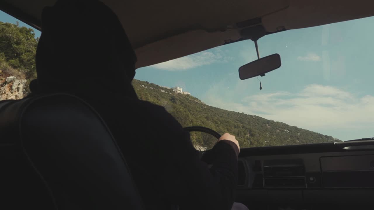 경치 좋은 산길 에서 빈티지 자동차 를 운전 하는 사람