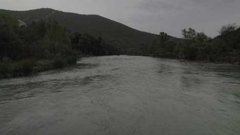 this drone video features a sam kolder-style shot, flying under an ancient bridge and pulling away to a bird's-eye view over the gállego river in anzánigo, spain. stunning visuals!