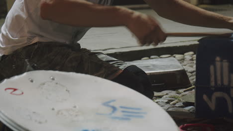 fast paced bucket drumming by a busker on the street during summer festival