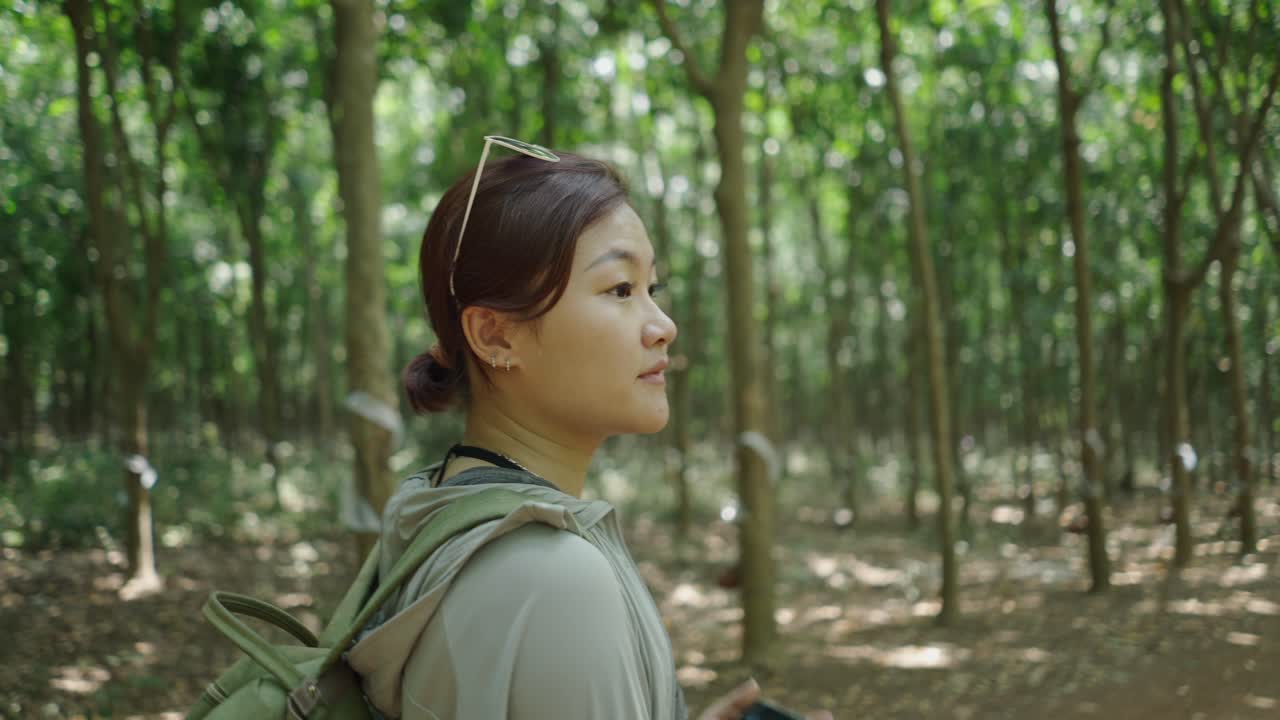 Woman taking picture in a rubber plantation