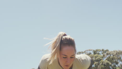 fit caucasian female soldier going over and under hurdles on army obstacle course in the sun