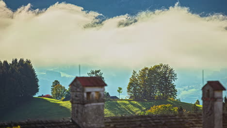 Paisaje-De-Lapso-De-Tiempo-En-Los-Campos-De-Los-Alpes-Austriacos-Casas-Tradicionales-Cielo-En-Movimiento,-Nubes-En-Movimiento,-Arquitectura-Tradicional-En-Campos-Agrícolas-De-Hierba