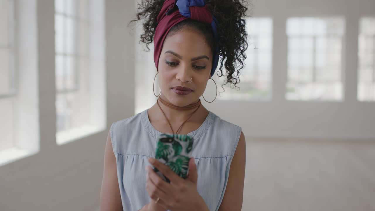 ritratto in slow motion di una giovane donna ispanica in un nuovo appartamento che invia messaggi di testo navigando utilizzando la tecnologia dei social media dello smartphone