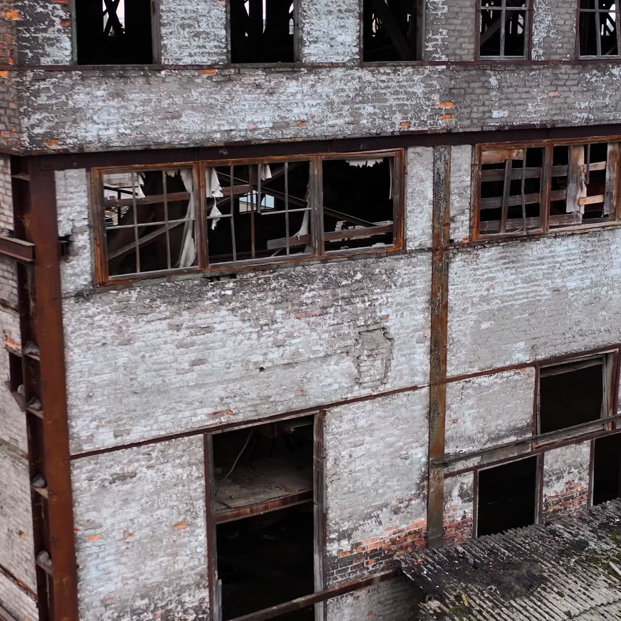 Damaged building with broken windows. Abandoned place after the war. Exterior of empty building during military actions.