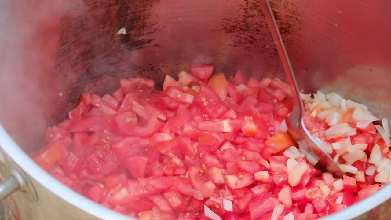 cámara lenta de la olla de comida militar kosher con cebollas y tomates fritos en el aceite mientras se mezclan