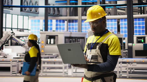 vertical video portrait of smiling technician in solar panels factory oversees assembly lines