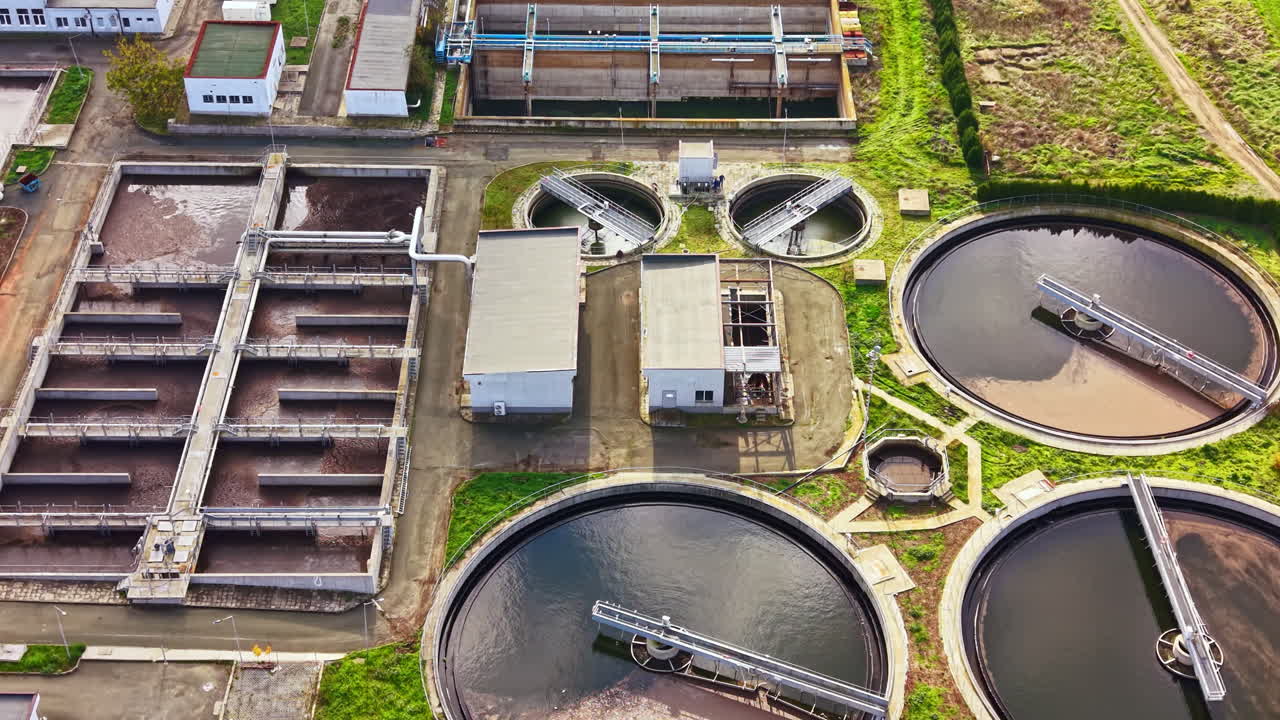 View of a wastewater treatment facility showcasing tanks and processing units on a sunny day