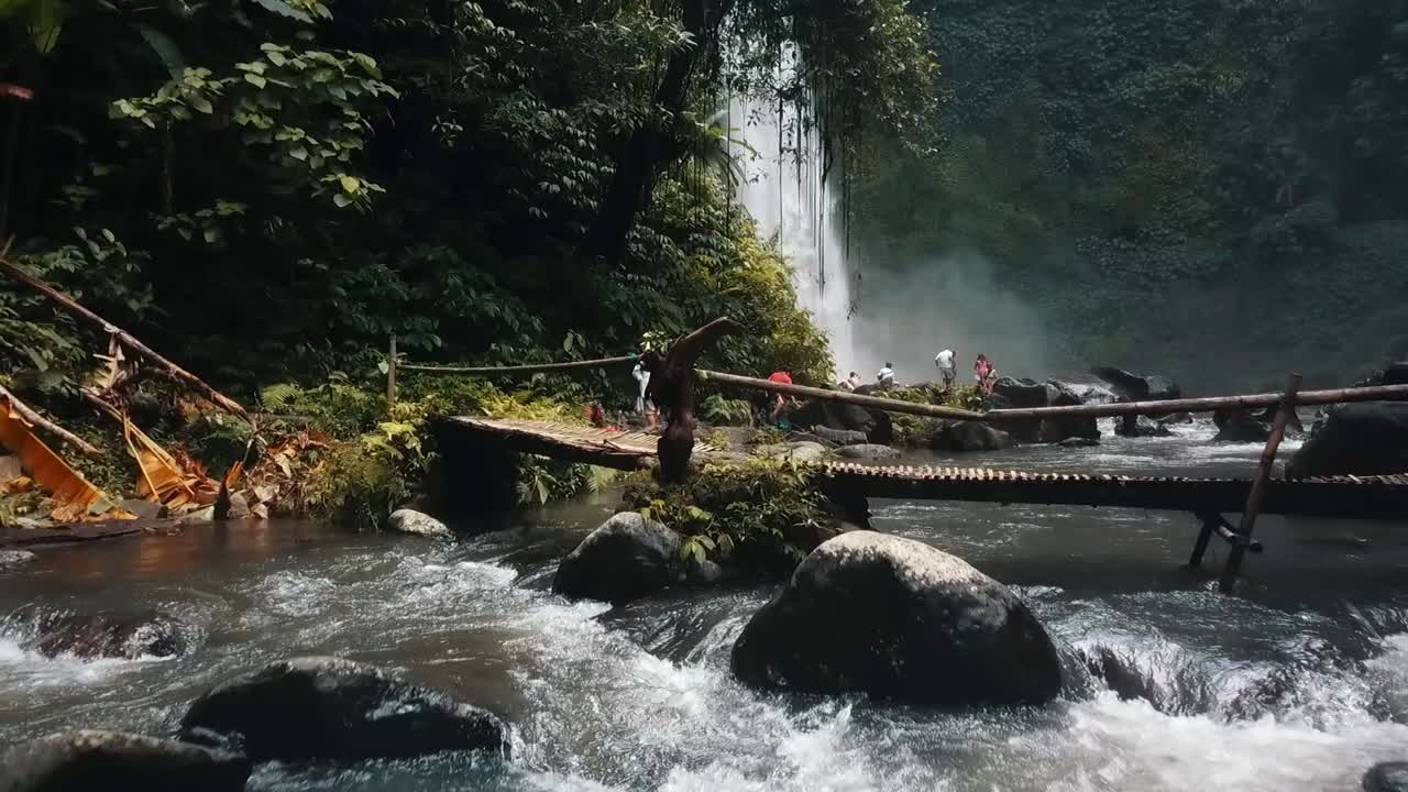 Bali, Spring 2020 in 1080 60p, Daytime, cinematic drone flight Long slow motion backward flight over a indigenous bridge backwards and slowly down to almost the river