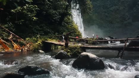 bali, primavera de 2020 en 1080 60p, durante el día, vuelo cinemático de drones largo vuelo lento hacia atrás sobre un puente indígena hacia atrás y lentamente hasta casi el río