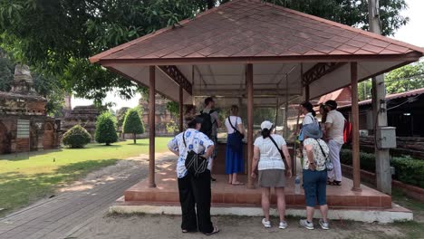 group of tourists visiting and photographing a pavilion