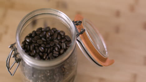 pouring coffee beans into mason jar with lid in slow motion