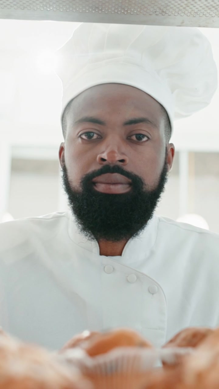 Chef professionista che osserva pasticcini appena sfornati in panetteria