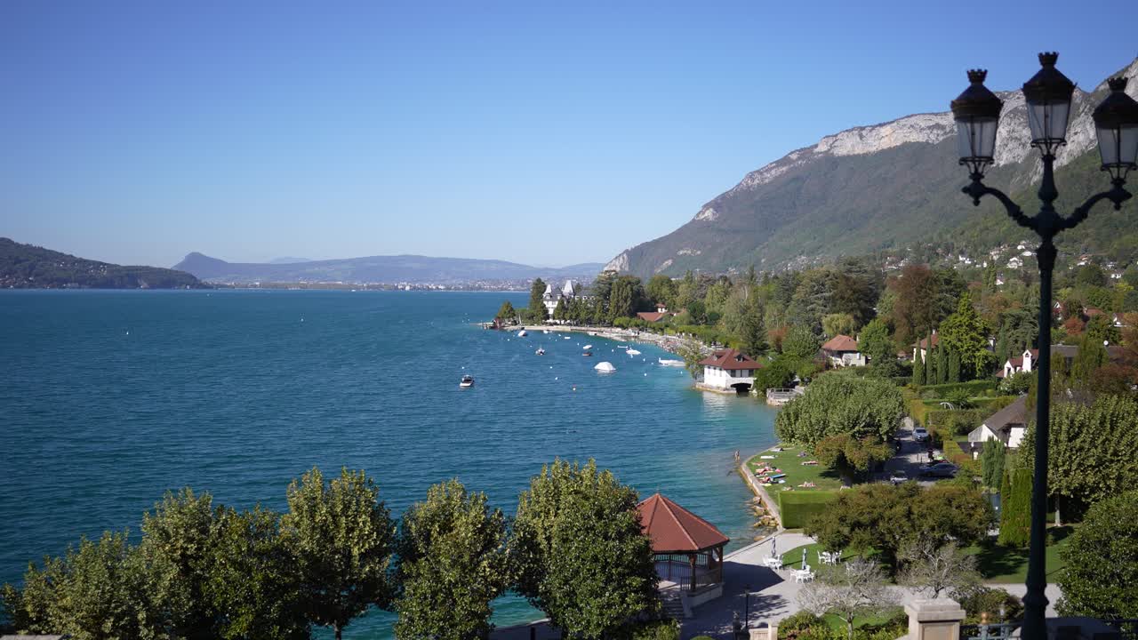 Lago di Annecy con gazebo sottostante vicino alla riva nelle Alpi francesi, inquadratura ampia fissa.