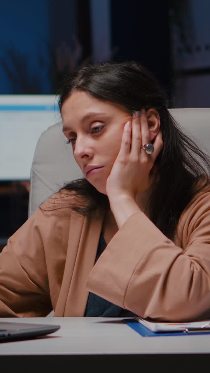 Video verticale: Ritratto di manager stanco e stacanovista che controlla le statistiche economiche usando un computer portatile.