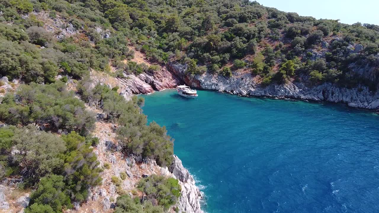 Aerial dolly shot approaching big boat in paradisiacal bay in Turkey