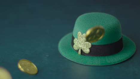 studio shot of green leprechaun top hat and falling gold coins to celebrate st patricks day 2