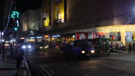 vehicles driving on historical colon street at night in cebu city, philippines. wide shot