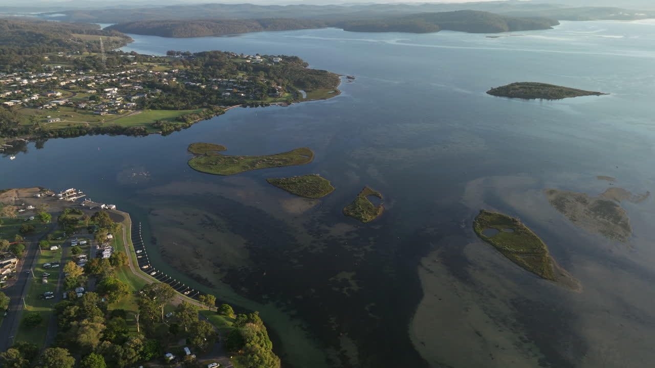 Aerial View of Mallacoota, Australia, Foreshore Camping Ground, Low Residential Buildings and small Islands, Summer's Day, Wide Establishing