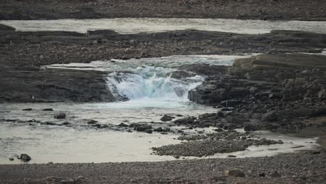 waterfall flowing through rocky rundra