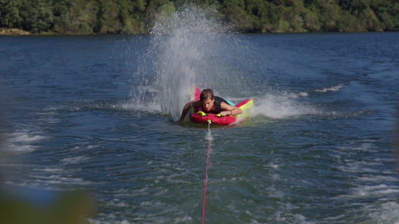 adolescente haciendo tubos en un lago.