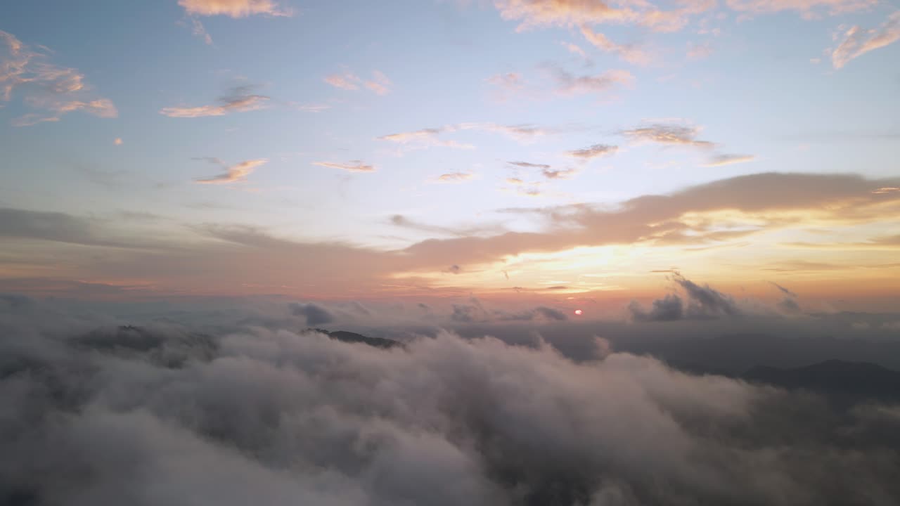 Volo di drone 4K su un cielo arancione al tramonto con sole e nuvole