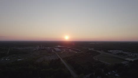 drone captura la puesta de sol en el horizonte creando un tono de color naranja sobre la pequeña ciudad