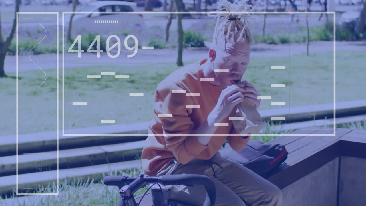 Cyclist sitting on bench opening sandwich eating during commute while overlay tracking data fading