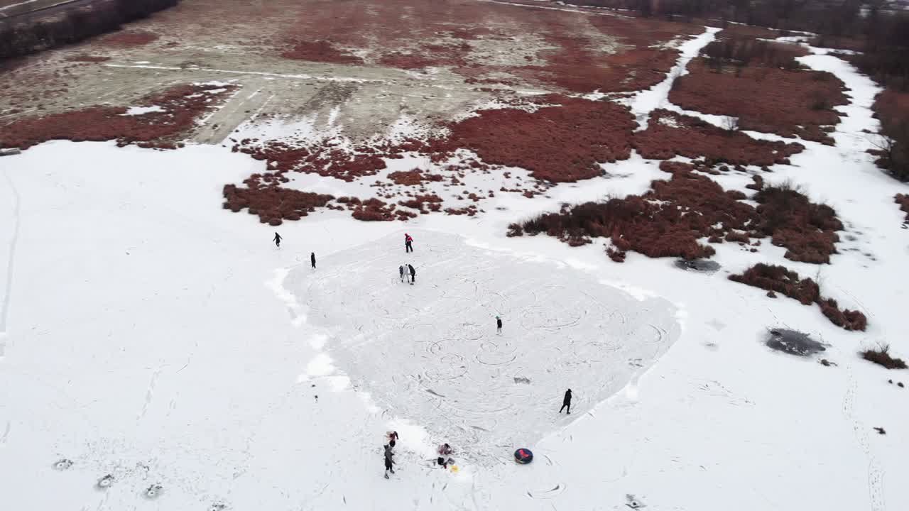 personas patinando sobre hielo en el lago congelado de la zona rural