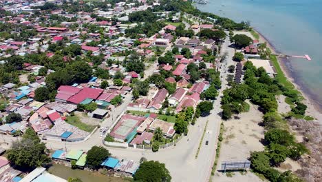 aerial drone of capital city dili in timor leste, south east asia, static of remote tropical island over buildings, traffic and ocean