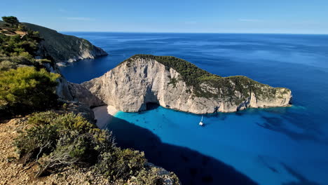 landscape pan of a navagio shipwreck beach smugglers cove bay with headland in greece zakynthos blue caves tourism travel holidays mediterranean sea