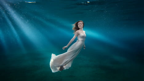woman in flowing white dress underwater