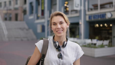 Retrato-De-Una-Turista-Rubia-Independiente-Usando-Una-Aplicación-Para-Teléfonos-Inteligentes-Navegando-Mensajes-De-Texto-Disfrutando-De-Los-Viajes-Por-La-Ciudad-Sonriendo-Optimista