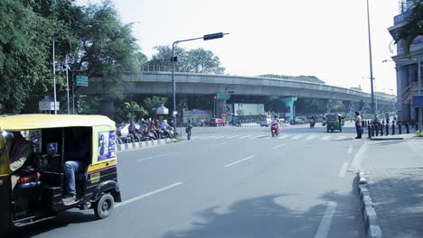 busy city street scene in india with elevated train