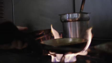 chef removing saucepan from stove