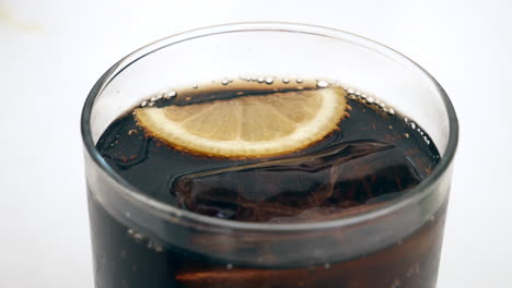 refreshing fizzy cola with ice and a lemon slice, perfect for beverage ads and summertime themes