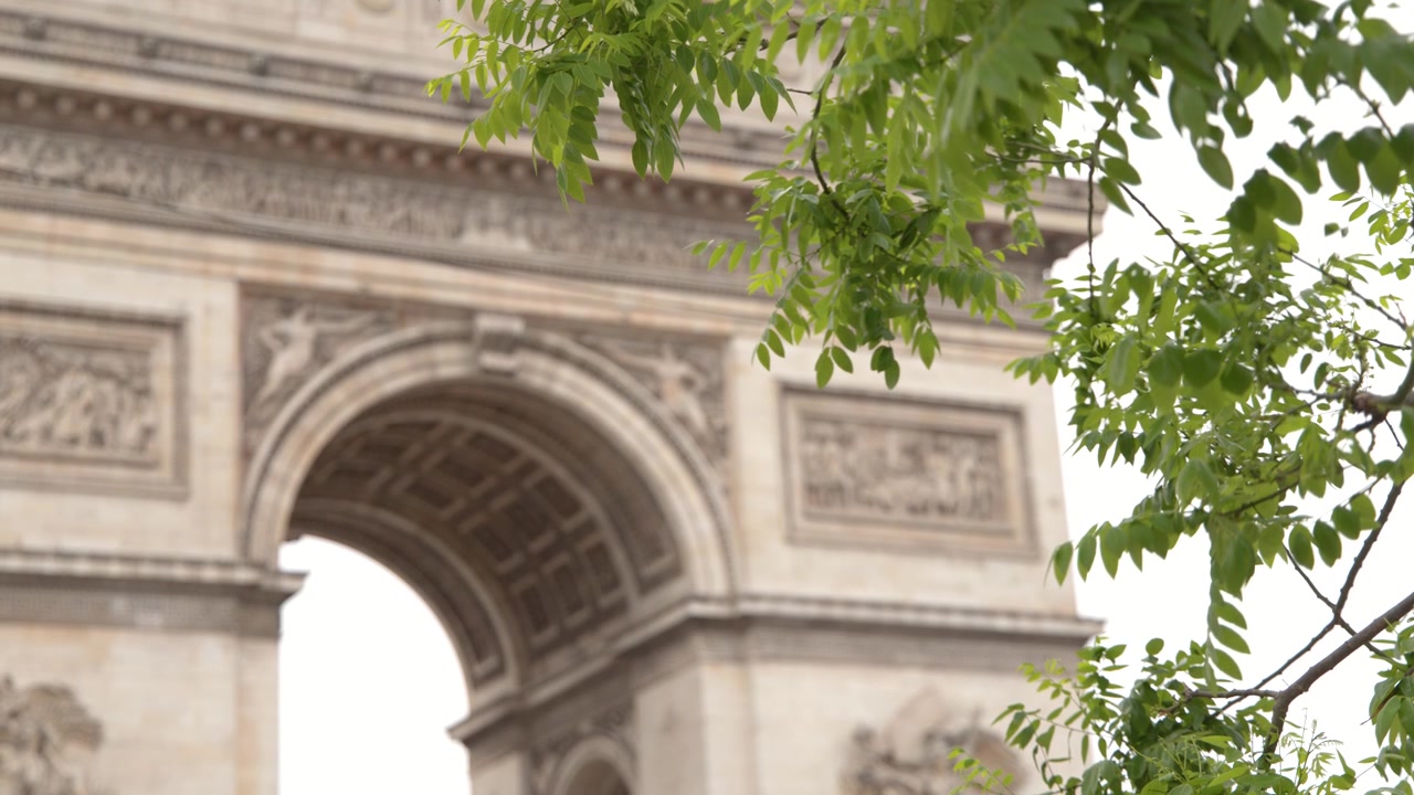 Inquadratura media statica dell'Arco di Trionfo attraverso il fogliame verde a Parigi, Francia