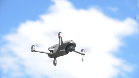 drone quadcopter flotando y volando, cielo azul con nubes en el fondo