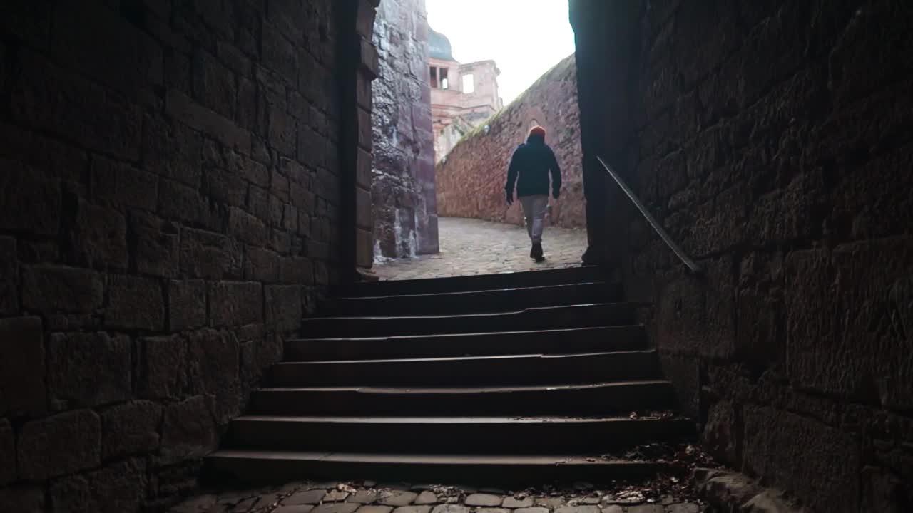 Person walking through a stone archway in a castle