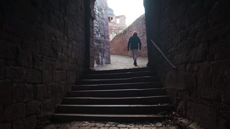 person walking through a stone archway in a castle