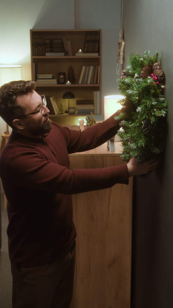 Man hanging a Christmas wreath